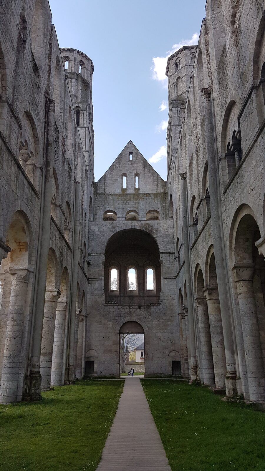 the nave of Jumièges Abbey looking towards the great arch at the end, roofless
