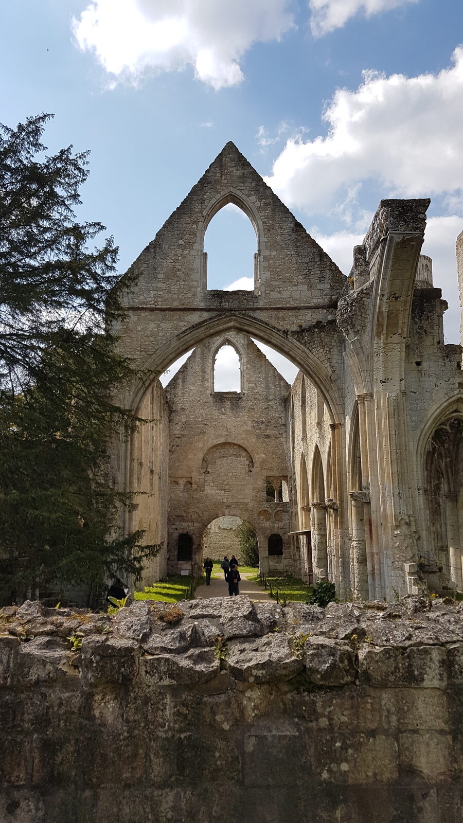 the gable and arcading of the church of Saint-Pierre at Jumièges, seen over the enclosure wall