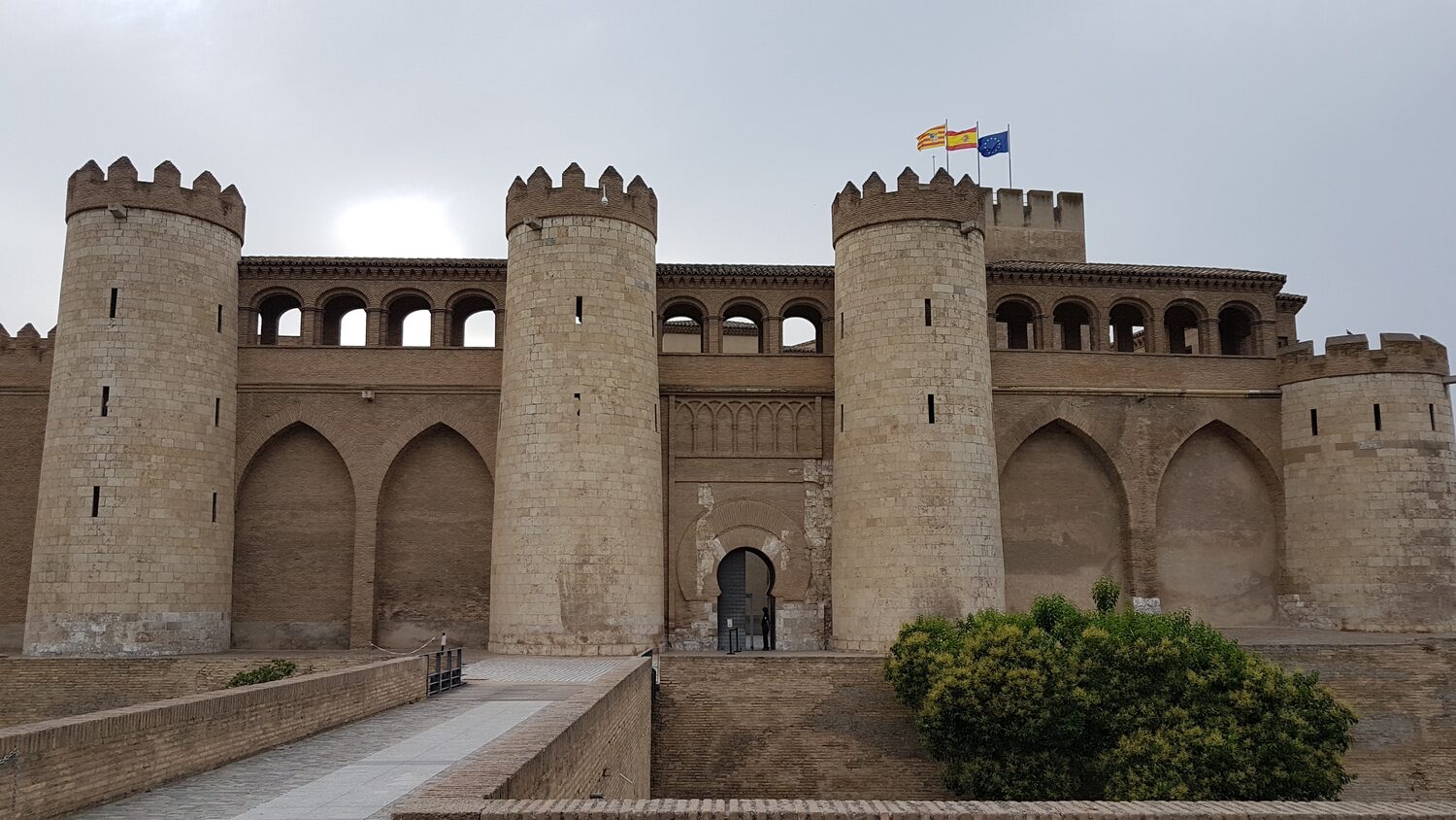 la facciata dell’Aljafería di Saragozza con le torri cilindriche e la porta d’ingresso ad arco