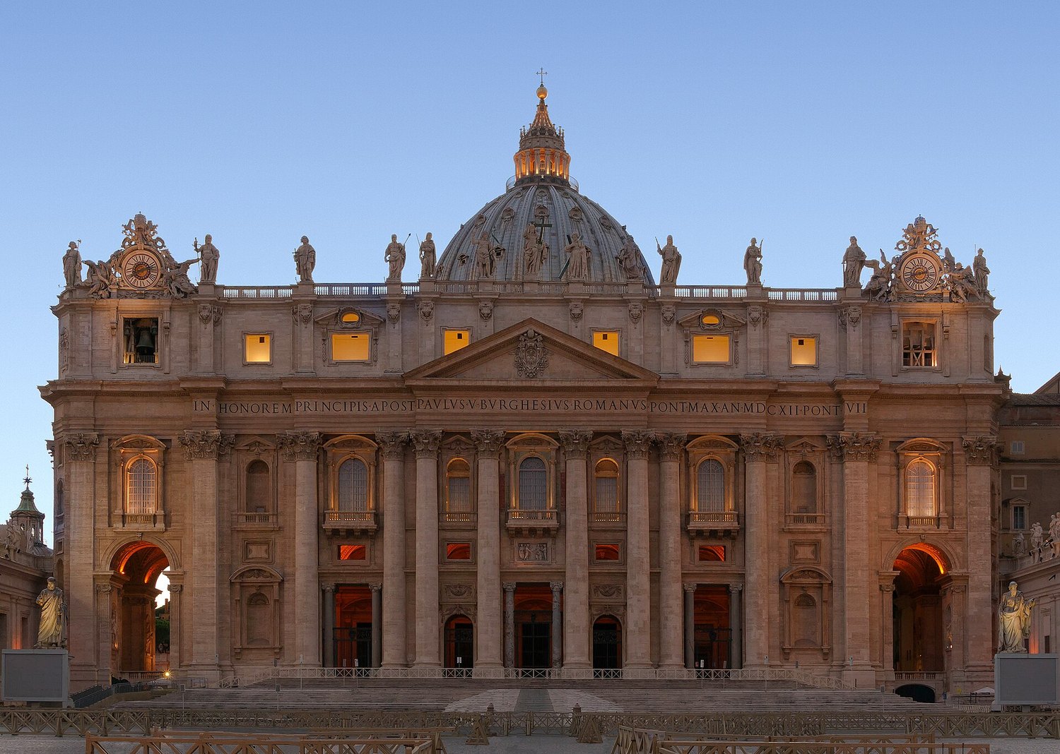 la fachada de Carlo Maderno de la basílica de San Pedro a la hora azul, con la cúpula de Miguel Ángel detrás y la inscripción de Pablo V