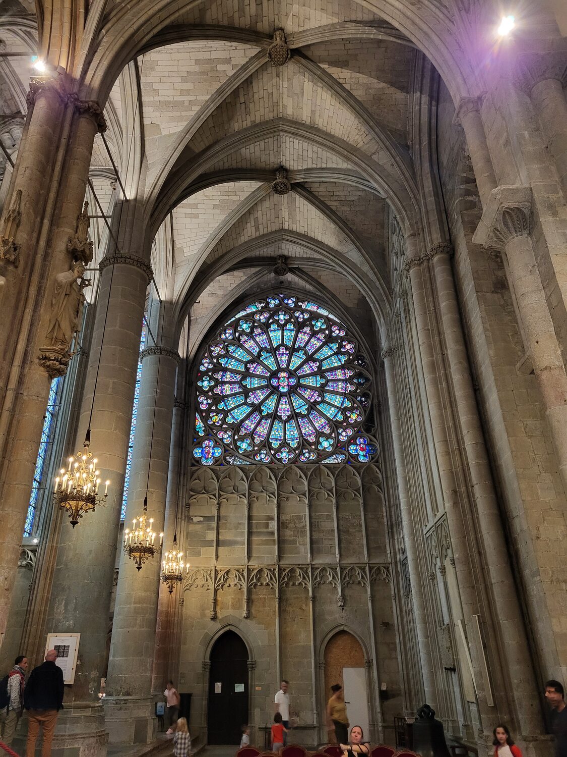el transepto gótico de la basílica de Saint-Nazaire en Carcasona con el rosetón y los pilares de la nave románica en primer plano