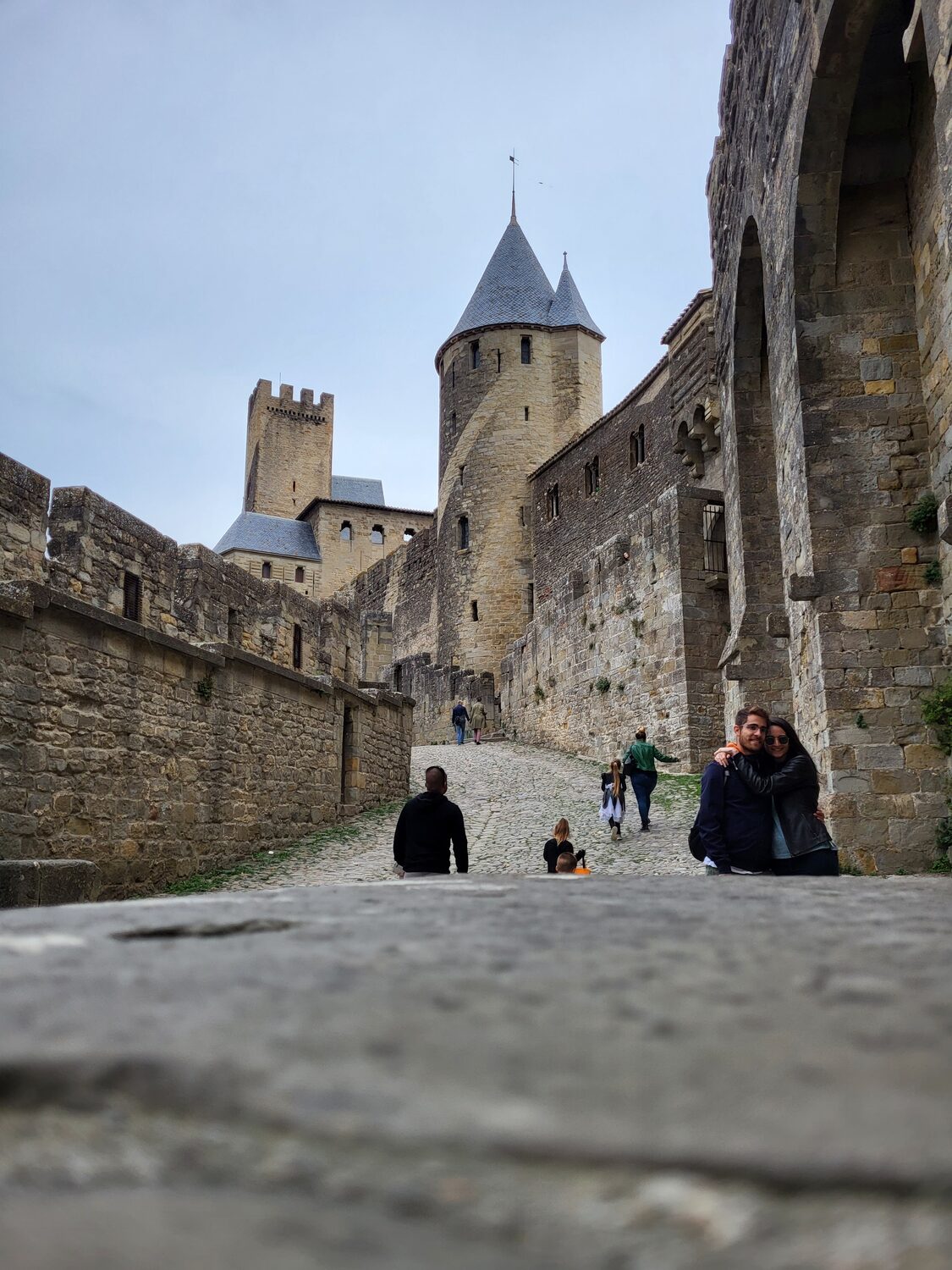 la rampa empedrada que sube hacia la puerta de Aude en Carcasona, con la torre Pinte cuadrada al fondo