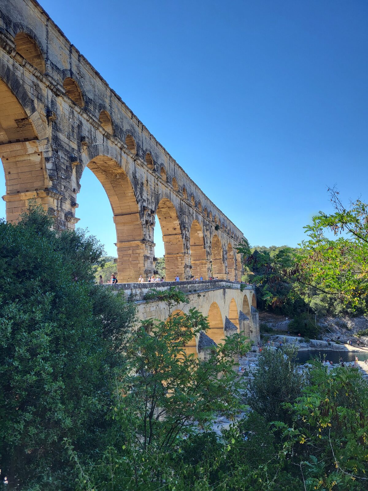 le arcate del Pont du Gard viste dal basso, con il ponte stradale addossato