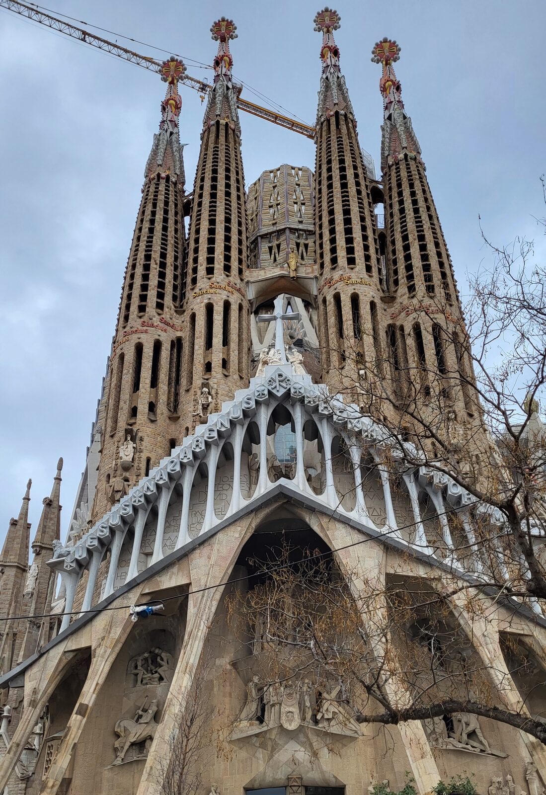la facciata della Natività della Sagrada Família dal basso, con le quattro torri e le gru